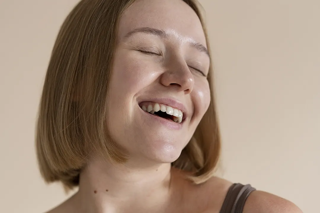 mujer joven sonriendo con rostro saludable
