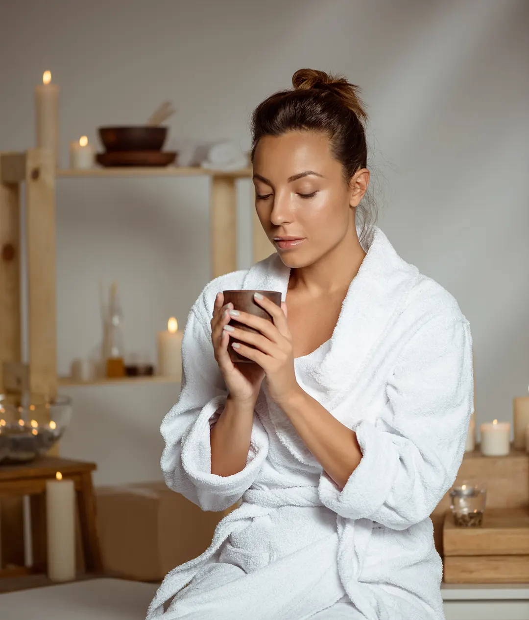 mujer con un té y bata en spa